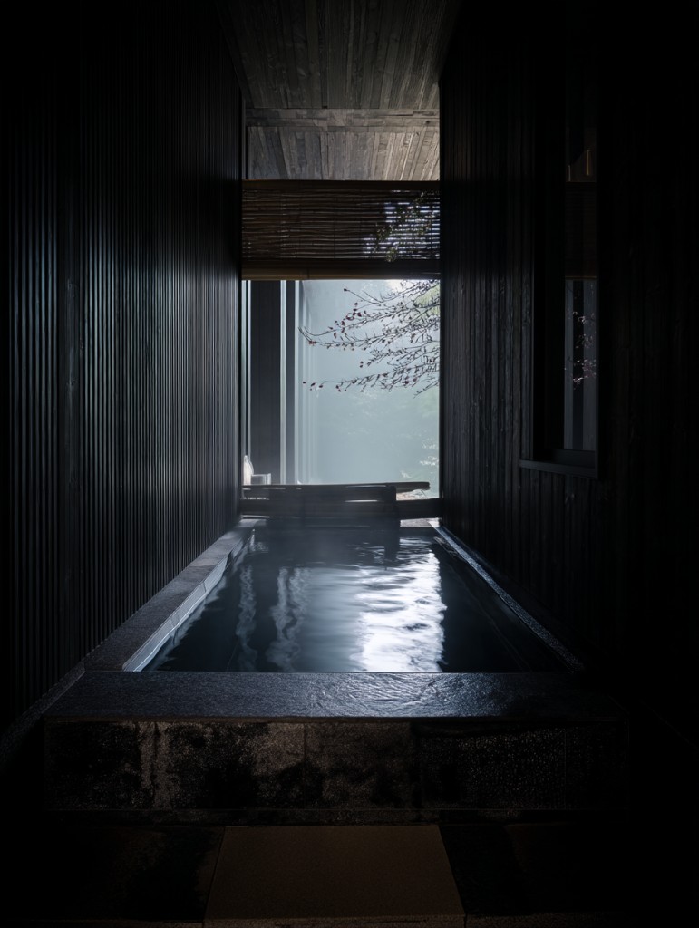 Dark timber onsen with a sakura branch in soft light